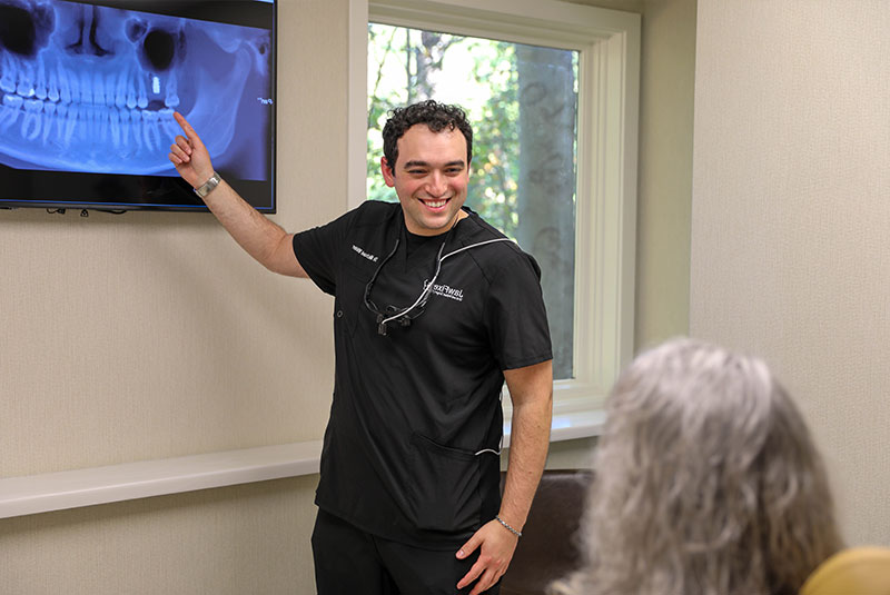 doctor pointing to patients implant on their x-ray